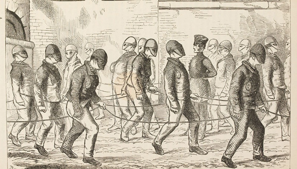 Convicts exercising at Pentonville Prison - Extrait de H. Mayhew and C. Bliny, The Criminal Prisons of London and scenes of prison life, 1862. A Londres, dans la prison de Pentonville, la communication visuelle entre détenus lors de la promenade est bloquée par l’usage qu’une visière surbaissée. La Belgique et la France ont préféré opter pour le capuchon belge, « préférable au bonnet à visière rabaissée qui n’empêche nullement de distinguer, avec un peu d’attention, les traits de celui qui le porte. » (Edou