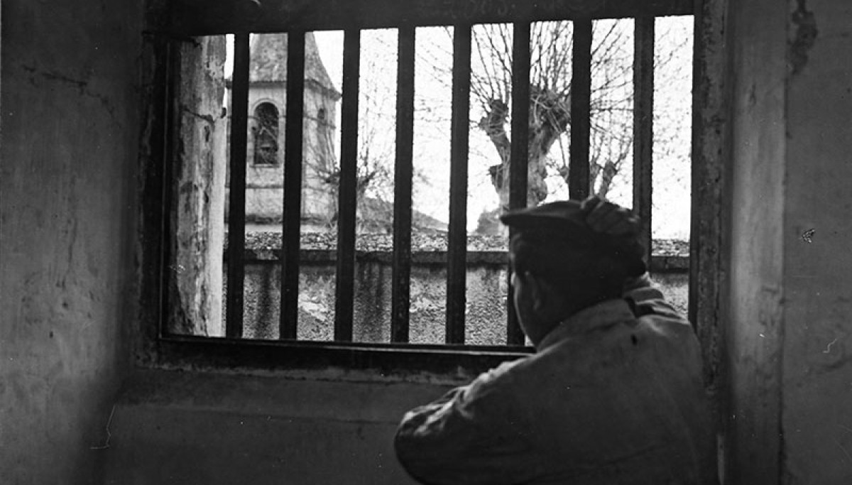 Maison d’éducation surveillée d’Eysses : pupille regardant à travers les barreaux, vers 1930 - Photographie d’Henri Manuel (Collection Michel Basdevant). La MES d’Eysses a un statut particulier : elle est « quartier correctionnel », c’est-à-dire qu’elle accueille les pupilles d’autres colonies considérés comme difficiles. Les adolescents (16-21 ans) y subissent une discipline particulièrement sévère et les traitements les plus rudes. Dans l’argot des colons, « aller défiler à Eysses » est la pire des perspe