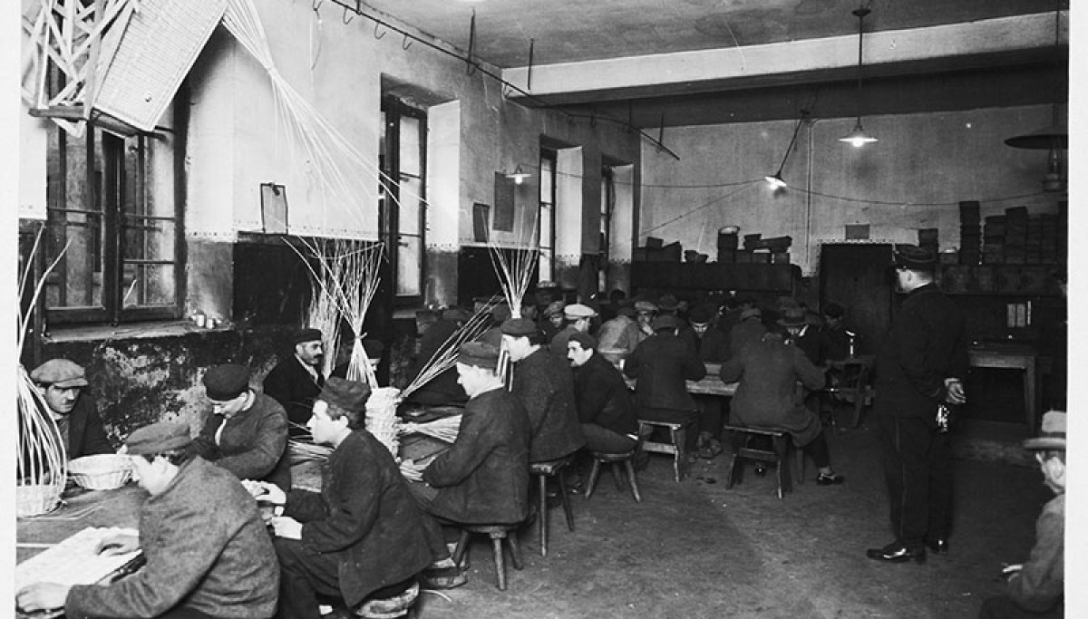 Maison d'arrêt de Metz : détenus au travail, vers 1930 - Photographie d’Henri Manuel (Coll. Enap-Crhcp). Sur cette photographie, on voit nettement la distinction faite entre condamnés et prévenus : les condamnés (au premier plan) portent la tenue pénale et les sabots, les prévenus (à l’arrière-plan) portent leurs effets personnels (chapeaux, chaussures …). 